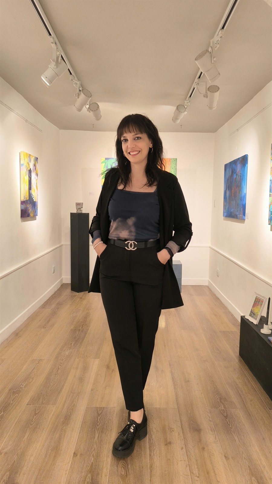 Evelin Puri en sala de exposición junto a sus obras